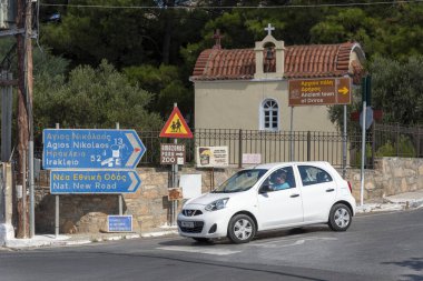 Neopolis, Kuzey Girit, Yunanistan. Ekim 2019. Eski Ulusal yolda, Neopolis 'e giden Girit' in tarihi bir kasabasında mavi yol işaretleri Agios Nikolaos 'u işaret eden küçük bir kilise var..