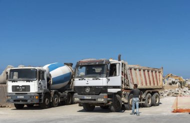 Rethymno, Batı Girit, Yunanistan. Eylül 2019. İnşaat alanındaki nakliye kamyonu ve çimento karıştırıcısı geliştirme için temizleniyor..