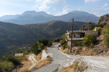 Agios Stefanos, Girit, Yunanistan. Eylül 2019. Girit 'in en eski köylerinden biri olan Agios Stefanos' un dağ yamacındaki Girit evinden geçen kırsal manzaralı bir yol. 