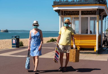 Southsea, Portsmouth, İngiltere, İngiltere. Mayıs 2020. Covid-19 salgını sırasında çift koruma amaçlı maske takarak Southsea sahil kasabasını ziyaret etti..