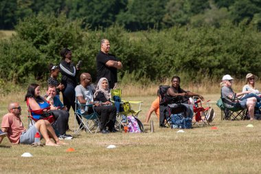 Basingstoke, Hampshire, İngiltere. Ağustos 2020. Coronavirus 'un kapatılmasına ilişkin kurallar gevşetildiği için insanlar ayakta durup bir çocuk futbol maçını izliyor..