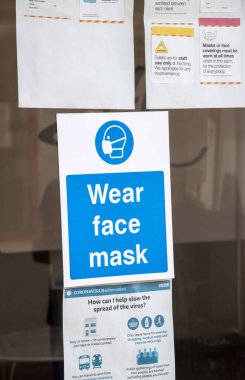 Wiltshire, İngiltere, İngiltere. 2020 yılı. Dükkan müşterilerine Coronavirus salgını sırasında bu ticari tesislere girerken yüz maskesi takmalarını tavsiye eden bir imza atın..