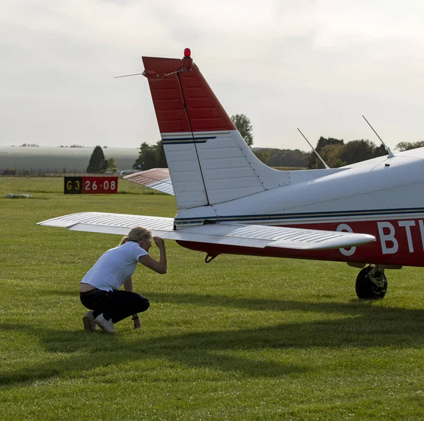 Gloucestershire, İngiltere, İngiltere. 2020 yılı. Bir öğrenci İngiliz havaalanından hocasıyla uçuş dersi almak üzere. Öğrenci pilot arka uçağı kontrol ediyor..