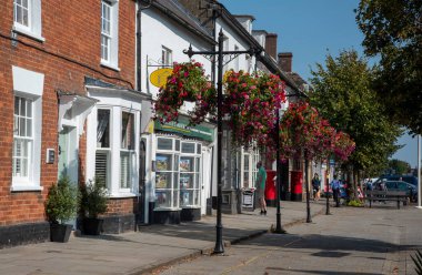 Royal Wootton Bassett, Wiltshire, İngiltere. 2020 yılı. Royal Wootton Bassett 'te ana cadde boyunca kuzeye bakan bir manzara. İngiltere' nin Wiltshire kentindeki bir pazar kasabası. Asılan sepetler sergileniyor..