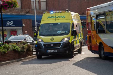 Margate, Kent, İngiltere. 2020 yılı. Bağrışan bir ambulans yoğun trafikte bir araba ve yerel bir otobüsün içinden geçiyor. ,