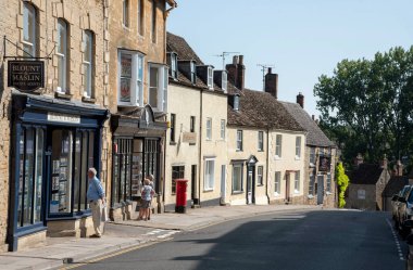 Malmesbury, Wiltshire, İngiltere, İngiltere. 2020 yılı. İnsanlar Malmesbury 'deki High Street' te bir emlak acentesinin vitrinine bakıyor. Yaşamak için uygun bir yer.,