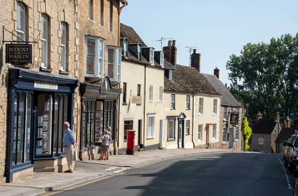 Malmesbury, Wiltshire, England, UK. 2020.  People viewing an estate agents window on the High Street in Malmesbury a desirable location to live,