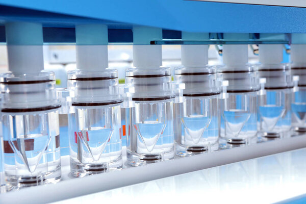 Obtaining precise results of analyzes of difficult soluble drugs. The girl is doing tests in pharmaceuticals. Sotax Ag. Production and analysis of tablets. Modern pharmaceuticals. Factory producing tablets. Laboratory of quality.