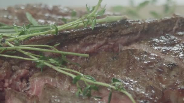 Wasser auf ein leckeres mittelseltenes Steak sprühen — Stockvideo