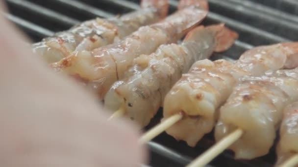 The hand overturns the frying shrimps — Stock Video
