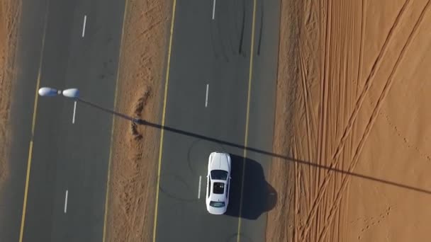 White SUV rides the desert highway. View from above. — Stock Video