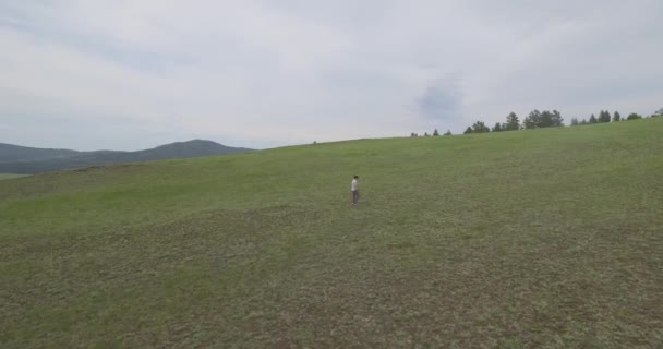 Una vista lateral de un hombre caminando en las tierras altas — Vídeos de Stock