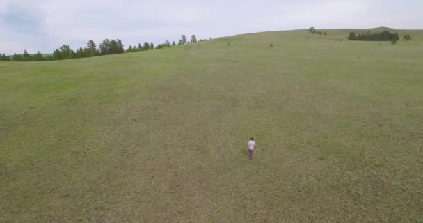 Drone video de un hombre caminando en las tierras altas — Vídeo de stock