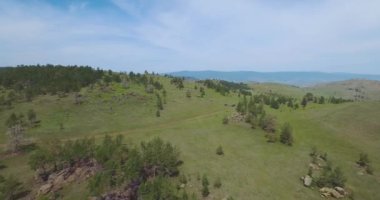 Baykal Gölü 'nün yakınındaki yeşil çayırların insansız hava aracı videosu. Bazı kadınlar, kayalar, vadiler, toprak yol ve bazı araçları olan insanlar var..