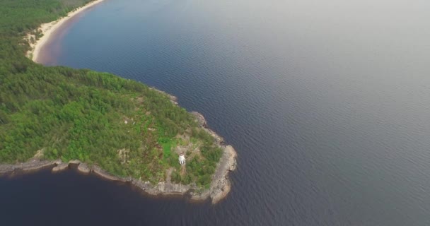 High upper flight over lighthouse on rocky cape among lake — Stock Video