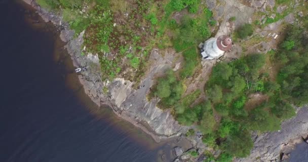 Круговой перелет над маяком на скалистом мысе к огромному озеру — стоковое видео