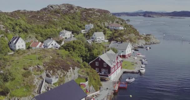 Полет над красивыми домами, расположенными на берегу фьорда в солнечный день — стоковое видео