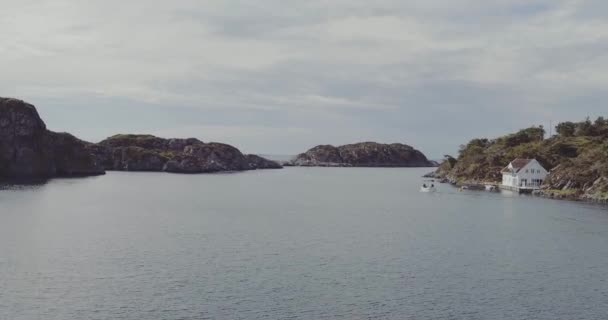 Vuelo sobre fiordo con barco pesquero pasando banco con casa — Vídeos de Stock