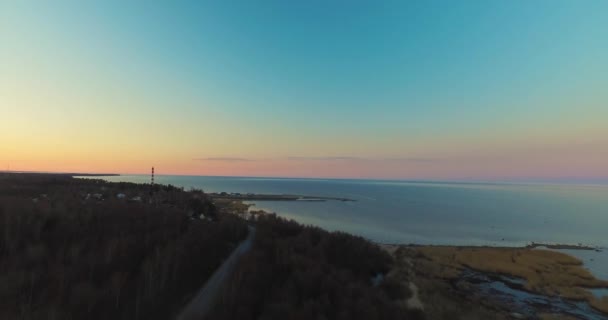 Donkere kust met gebouwen op Oceaan kust onder avondrood — Stockvideo