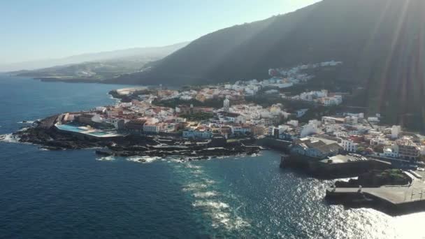 Bird eye flight city lit by sunlight near endless blue ocean — Stock Video