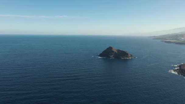 mouvement supérieur à l'île rocheuse par plage contre l'océan sans fin 