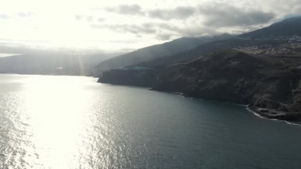 Vista panorâmica oceano tranquilo na costa rochosa contra a luz solar — Vídeo de Stock