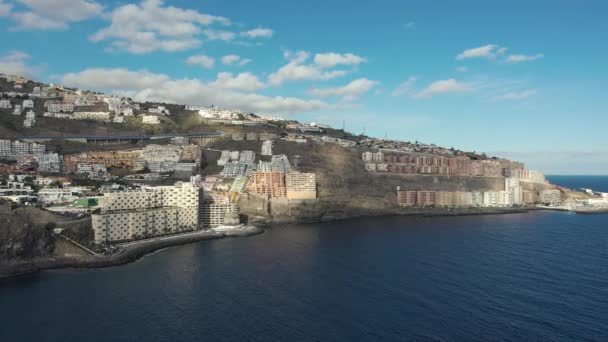 Верхний вид курортного города с отелями на скалистых холмах у океана — стоковое видео