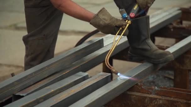 Travailleur utilise une machine à souder pour couper la poutre métallique gros plan — Video