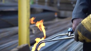 metal işçisi işçi metal kesmek için bir gaz kaynak makinesi ateşe ayarlar