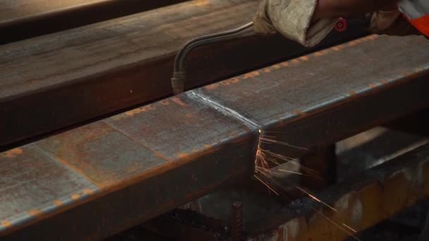 Ein professioneller Arbeiter in einem Metalllager schneidet einen großen Metallbalken durch Schweißen. Nahaufnahme — Stockvideo