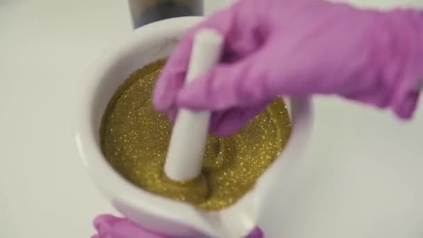 Scientist mixes gold powder in a mortar on a table top view — Stock Video