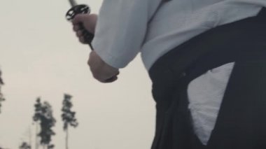 Geleneksel elbiseli adam eski Japon kılıcını tutuyor.