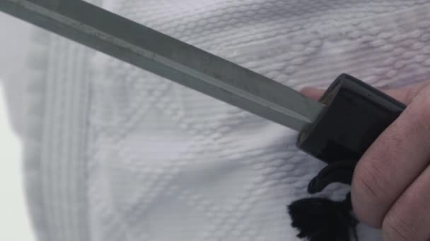 Man hands hide katana made of steel in hand made case closeup — Stock video