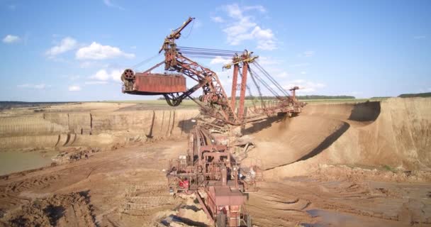 Büyük kahverengi kova tekerlek kazıcısı taş ocağında toprağı kazıyor. — Stok video