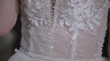 Zarif gelin tasarlanmış beyaz bir korse giyiyor.