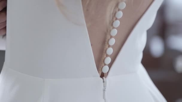 Elegante bruid terug met kleine witte knopen van trouwjurk — Stockvideo