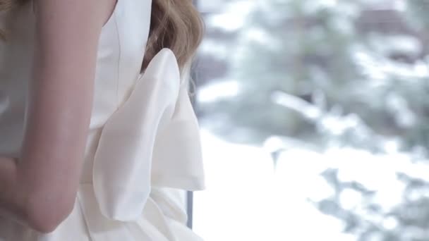 Blonde lady poses in white wedding dress with bow on back — Stock Video