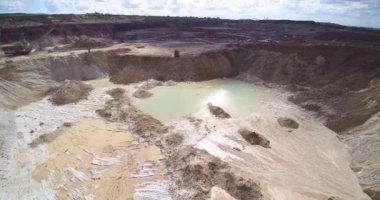 Taş ocağı çöp kamyonu silueti küçük gölün üstüne boşalıyor.