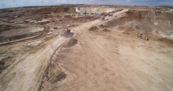 Steengroeve dumpers rijden langs bruine grond weg tussen kuilen — Stockvideo