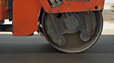 Gri ve turuncu renkli yol makineleri çakılları hizalar
