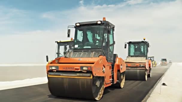 Rodillos de carretera conducen sobre grava asfaltada cruda de la nueva carretera — Vídeos de Stock
