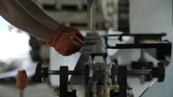 Wykwalifikowany pracownik umieszcza blachę na automatycznej maszynie do gięcia metalu — Wideo stockowe