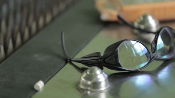 Людина бере чорні захисні окуляри з металевого столу — стокове відео