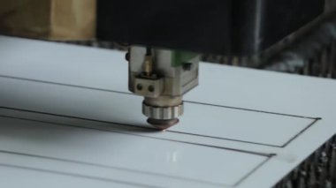 Gri lazer metal kesme makinesi beyaz sayfa üzerinde hareket ediyor