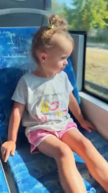 Küçük kız tramvay penceresinden hayranlıkla bakıyor, yolculuğu büyülü bir macera olarak görüyor. Çocukluk ve merakın atmosferi