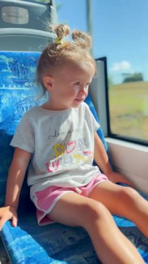 Küçük kız yolculuk sırasında tuhaf bir şekilde tren penceresinden dışarı bakıyor. Çocukluğun, seyahatin ve keşfin sembolü