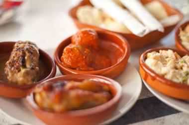 İspanyol tapas seçimi - Rus salatası, tavuk kanatları ve domates soslu köfte.