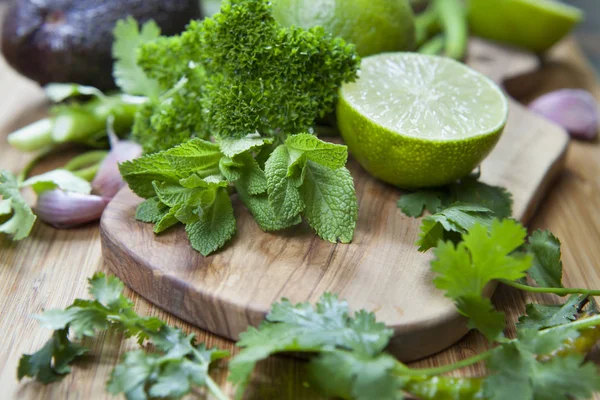 chopped limes with greens on wooden board