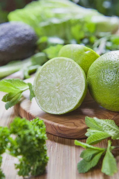 chopped limes with greens on wooden board