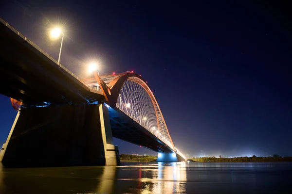 Bridge over the river Ob night. The lights of the bridge glow in the night sky.